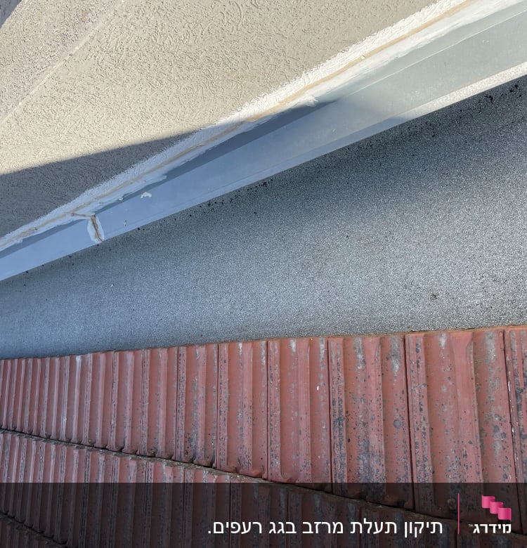 רעפים אדומים על גג עם חיפוי מתכת אפור